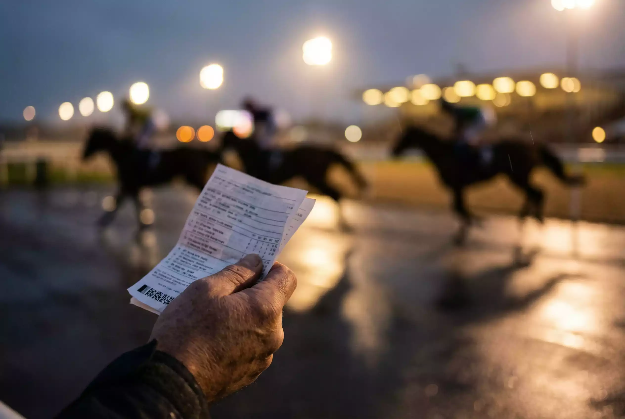 Multiple races in progress at Wolverhampton racecourse showing an evening card
