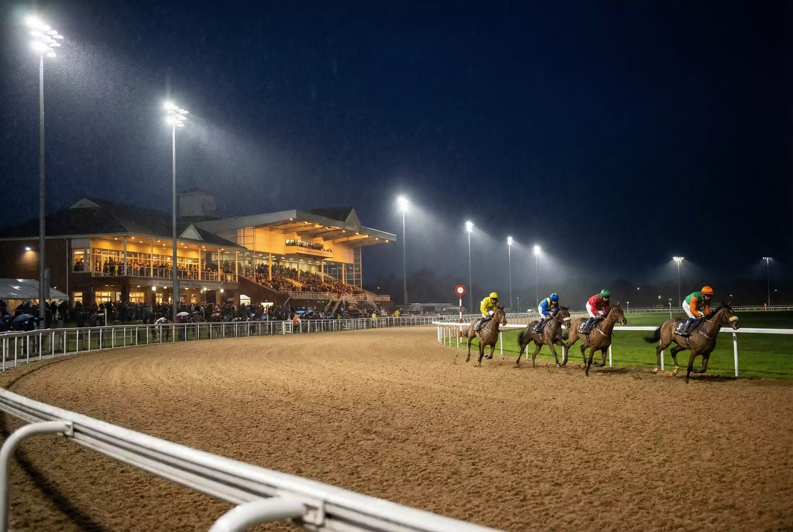 Wolverhampton racecourse illuminated by floodlights during an evening race meeting