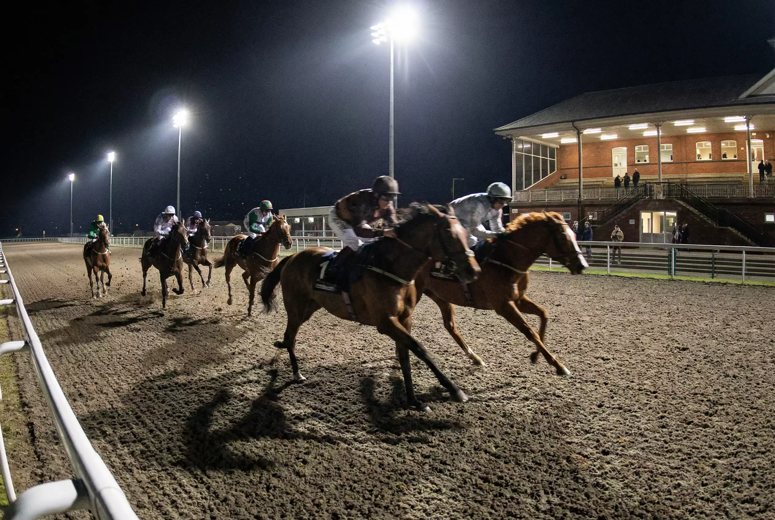 Horse racing action mid-race at Wolverhampton with the field rounding a bend